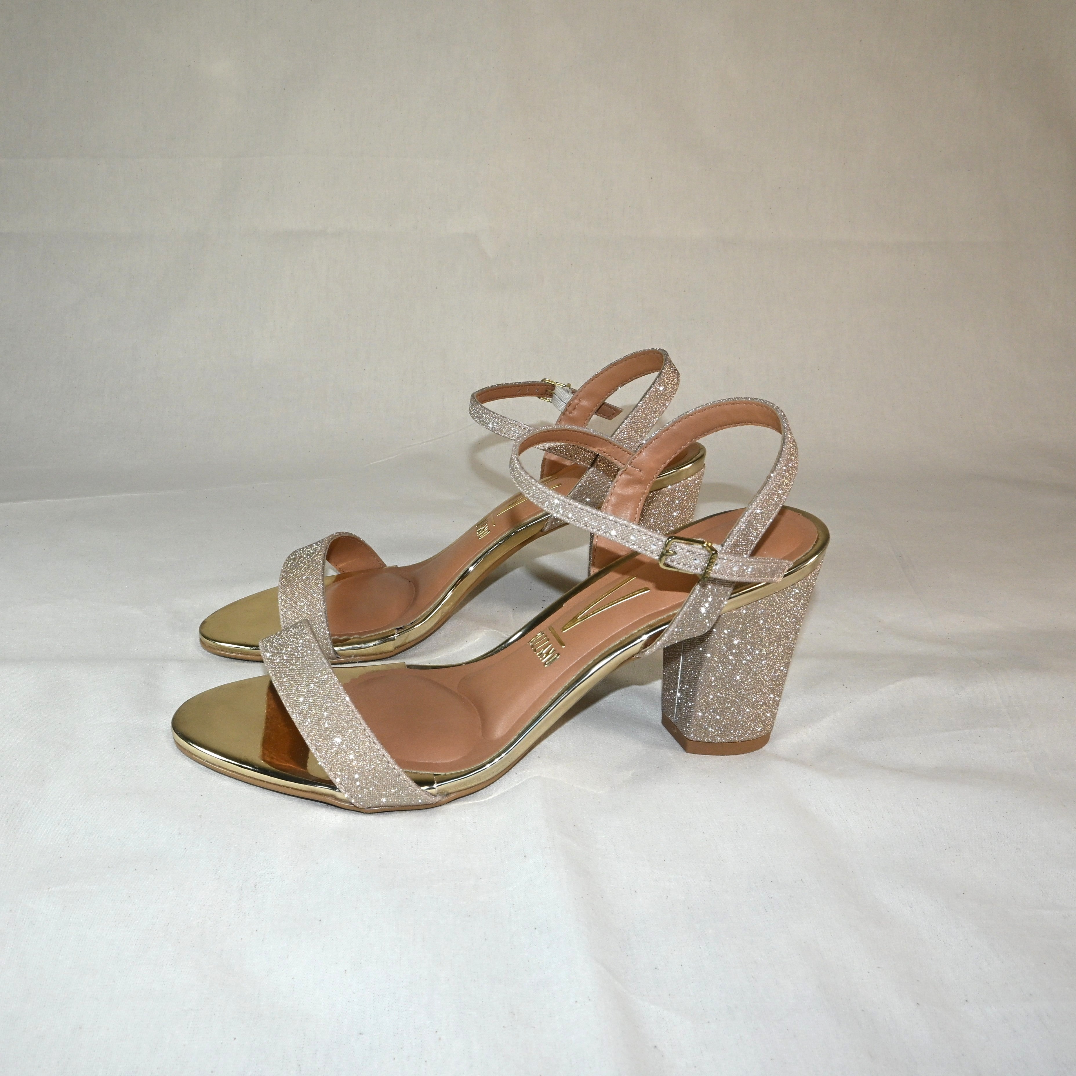 Sapato de salto alto dourado com brilho